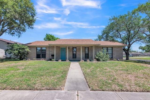 single story home with a porch, a front yard, and brick siding