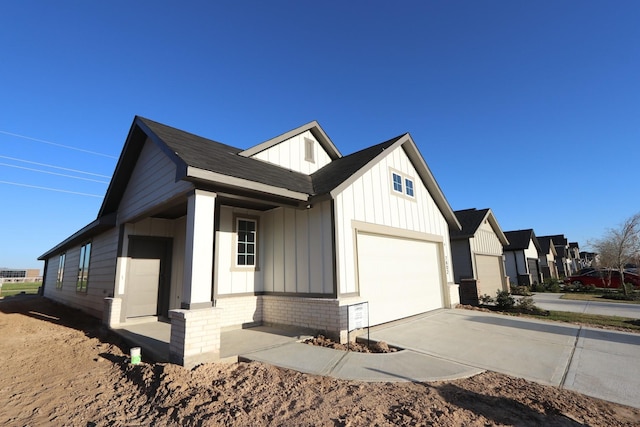 7602 Magnolia Orchid Ln, Cypress, TX 77433 - view of property exterior with an attached garage, board and batten siding, driveway, and brick siding