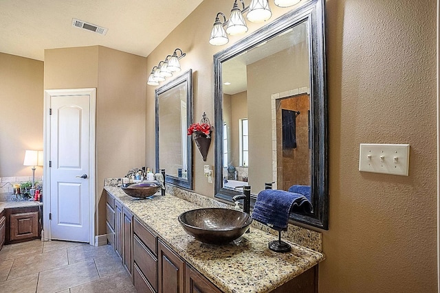 full bath with tile patterned floors, double vanity, a sink, and visible vents
