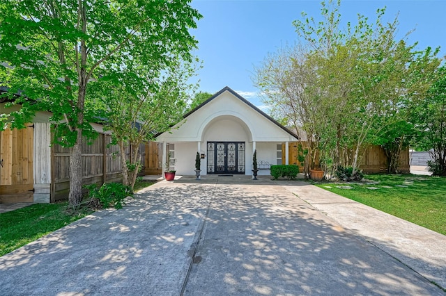 1265 Du Barry Ln, Houston, TX 77018 - view of front of home with fence, stucco siding, french doors, a front lawn, and driveway