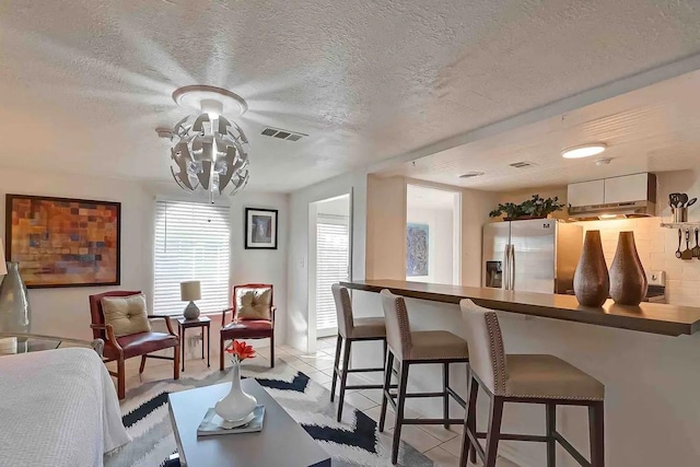 1265 Du Barry Ln, Houston, TX 77018 - interior space featuring a chandelier, a textured ceiling, light tile patterned floors, and visible vents