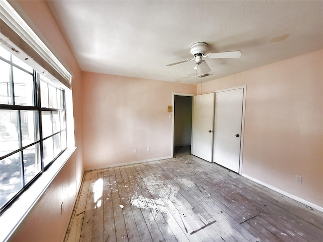 unfurnished bedroom featuring hardwood / wood-style floors, baseboards, and visible vents