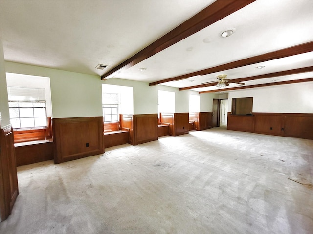 spare room with beamed ceiling, wainscoting, and a wealth of natural light