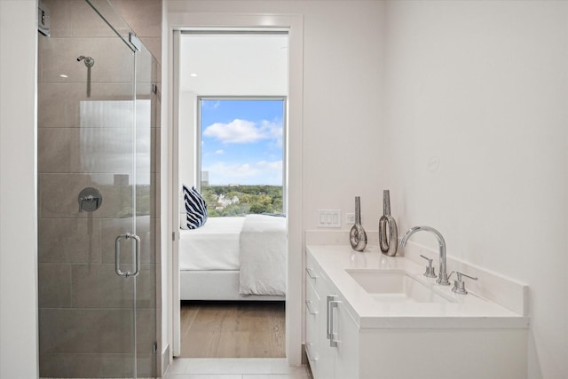 full bath featuring wood finished floors, ensuite bathroom, vanity, and a stall shower