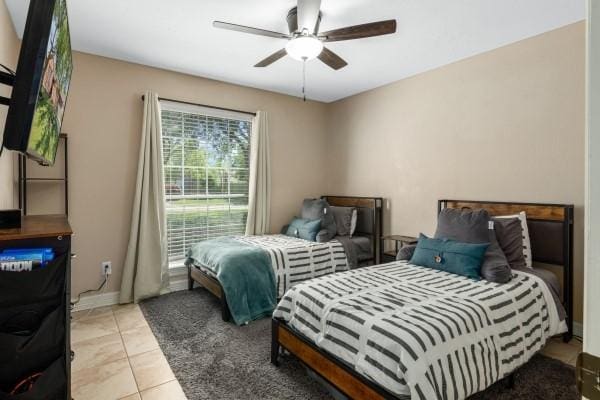 bedroom with baseboards, a ceiling fan, and light tile patterned flooring