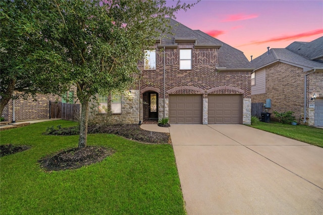 view of front of property featuring a yard, driveway, a garage, and stone siding