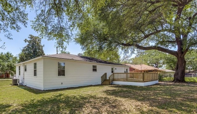 back of property featuring a wooden deck, a lawn, central AC unit, and fence