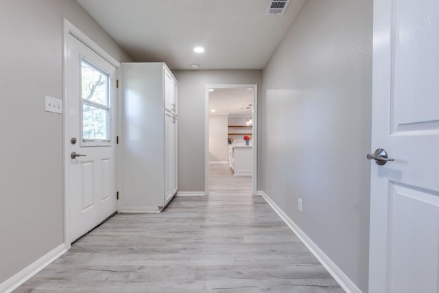 hallway with baseboards, light wood finished floors, visible vents, and recessed lighting