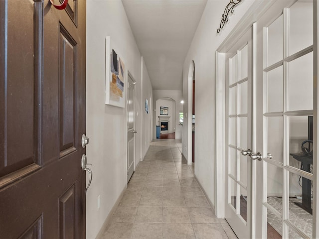 605 Pedernales St, Webster, TX 77598 - hall with arched walkways, light tile patterned floors, and baseboards