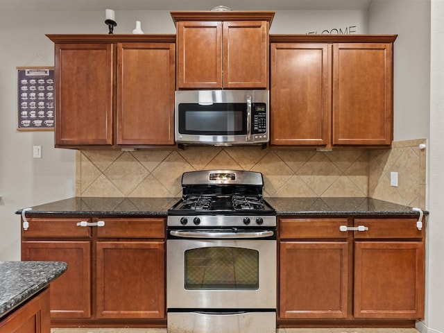 605 Pedernales St, Webster, TX 77598 - kitchen with appliances with stainless steel finishes, dark stone counters, backsplash, and brown cabinets