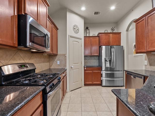 605 Pedernales St, Webster, TX 77598 - kitchen with stainless steel appliances, recessed lighting, arched walkways, dark stone countertops, and backsplash