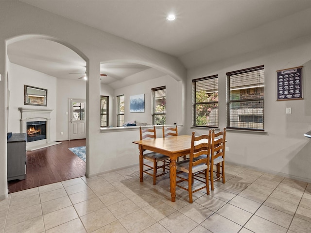 605 Pedernales St, Webster, TX 77598 - tiled dining space with ceiling fan, a lit fireplace, recessed lighting, lofted ceiling, and baseboards
