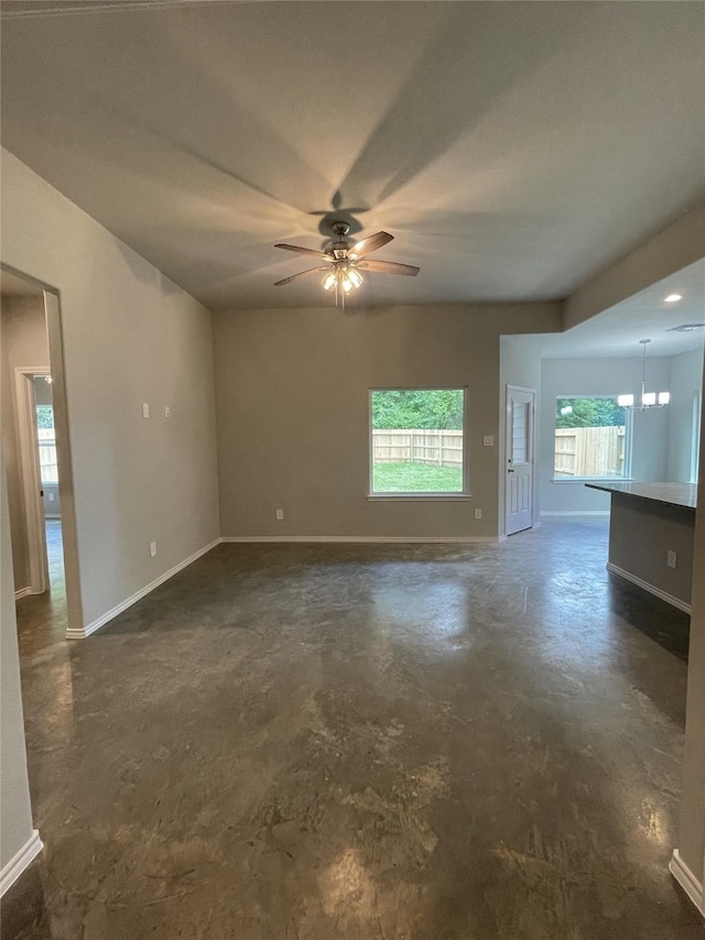 15838 Aspen Dr, Montgomery, TX 77356 - unfurnished living room with a ceiling fan, unfinished concrete floors, baseboards, and a chandelier