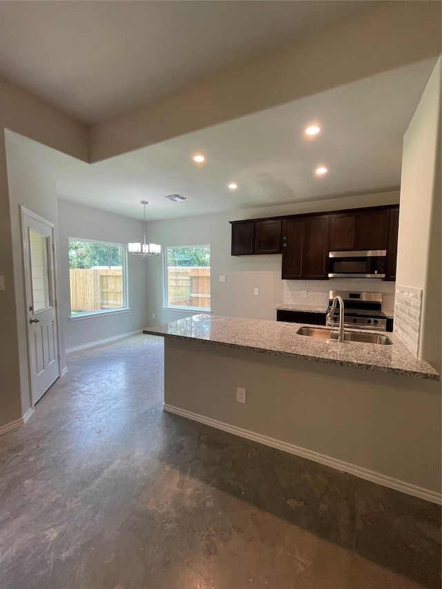 15838 Aspen Dr, Montgomery, TX 77356 - kitchen with stainless steel appliances, a chandelier, light stone countertops, dark brown cabinetry, and a sink