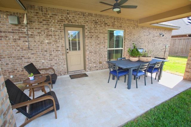 view of patio / terrace featuring outdoor dining space, fence, and a ceiling fan