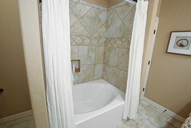 bathroom with shower / bath combo and baseboards