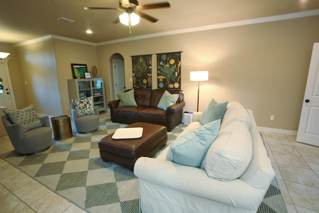 living area featuring visible vents, light tile patterned floors, arched walkways, a ceiling fan, and crown molding