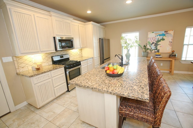 kitchen featuring a sink, ornamental molding, backsplash, and stainless steel appliances