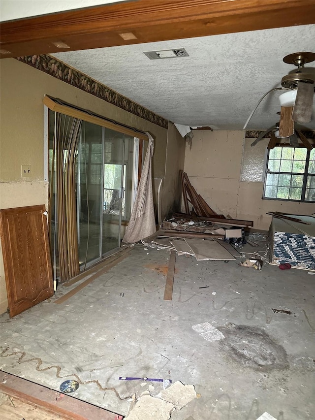 spare room with a textured ceiling, a ceiling fan, and visible vents