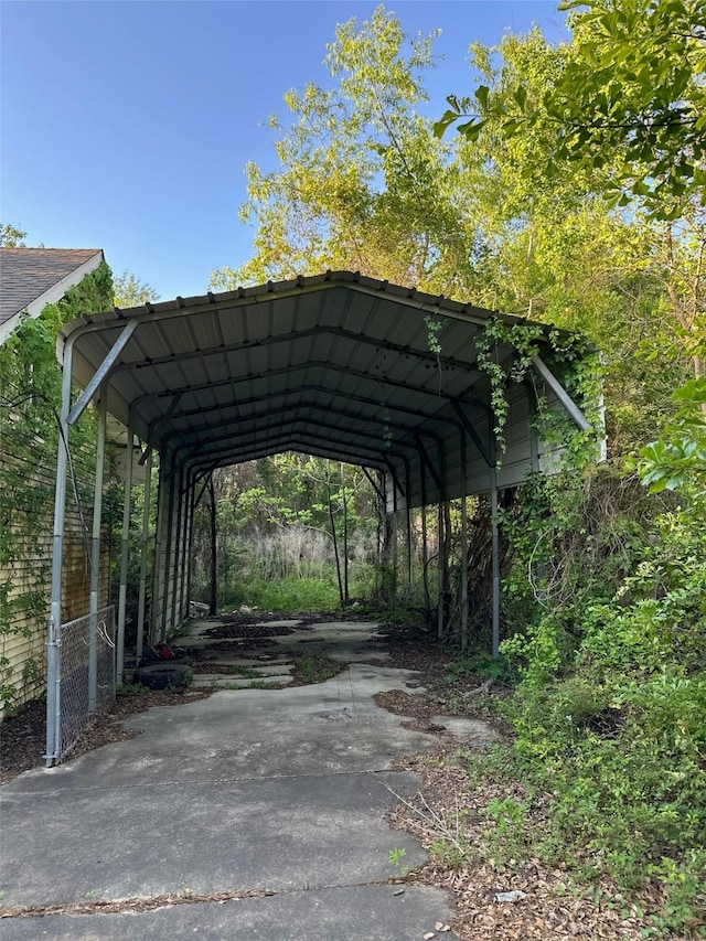 view of vehicle parking with a carport and fence