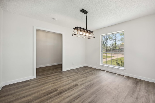 12418 A Bar Dr, Santa Fe, TX 77510 - unfurnished dining area with dark wood-style floors, a textured ceiling, baseboards, and a chandelier