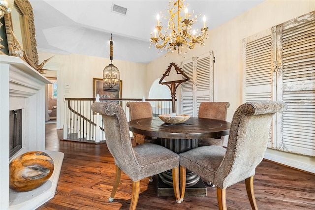 dining room featuring wood finished floors, visible vents, baseboards, and a notable chandelier