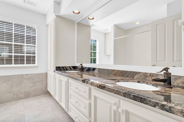 bathroom featuring recessed lighting, double vanity, a shower, and tile patterned flooring