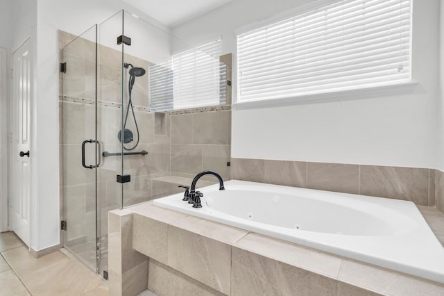 bathroom with a stall shower, a tub with jets, and tile patterned flooring