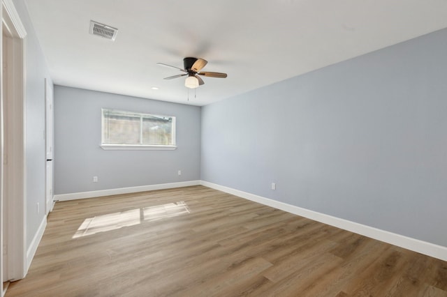 unfurnished room with baseboards, light wood-style flooring, visible vents, and ceiling fan