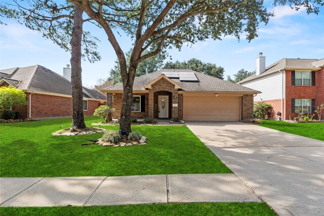 3030 Glenthorpe Ln, Katy, TX 77494 - view of front of house featuring a front lawn, brick siding, a garage, concrete driveway, and solar panels