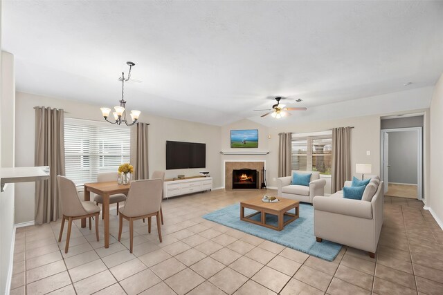 3030 Glenthorpe Ln, Katy, TX 77494 - living area featuring lofted ceiling, a tiled fireplace, light tile patterned floors, and ceiling fan with notable chandelier