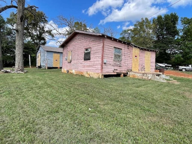 view of home's exterior featuring a yard, a storage unit, and an outbuilding