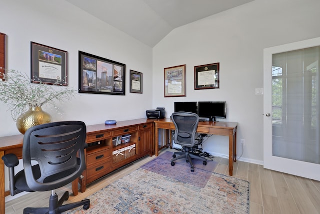 office with vaulted ceiling, light wood-type flooring, and baseboards