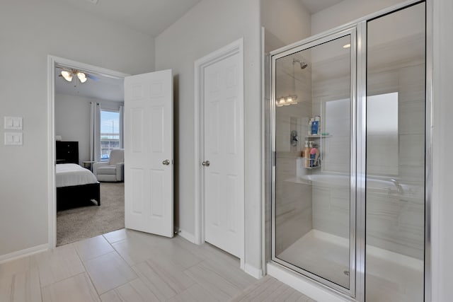 bathroom featuring a stall shower, ensuite bathroom, and baseboards