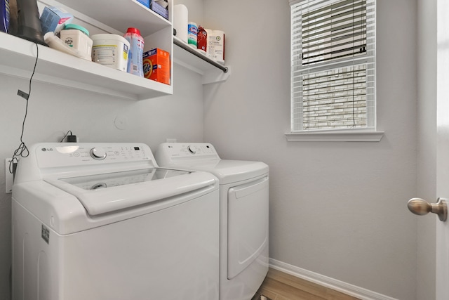 laundry area with independent washer and dryer, baseboards, and wood finished floors