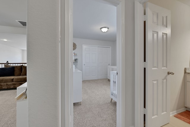 corridor with light carpet and baseboards