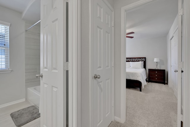 bathroom with healthy amount of natural light, shower / bath combination, ensuite bathroom, and baseboards
