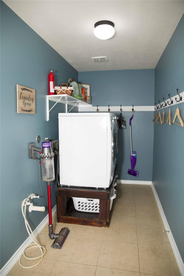 laundry area with laundry area, tile patterned flooring, visible vents, baseboards, and washer / clothes dryer