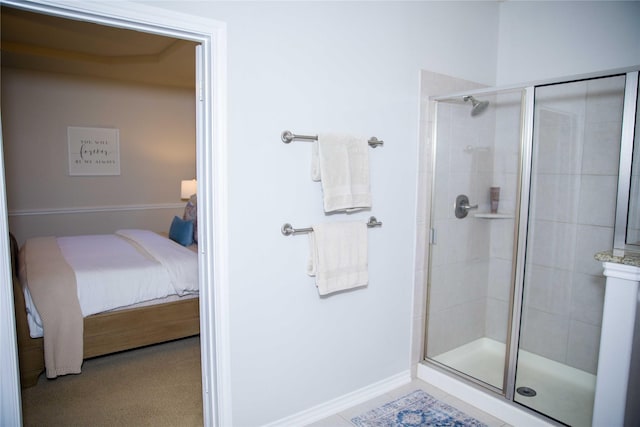 ensuite bathroom featuring ensuite bathroom, baseboards, and a stall shower