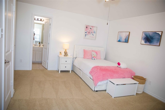 carpeted bedroom with baseboards, a sink, and ensuite bathroom