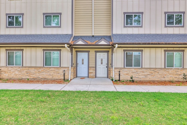 12603 Telge Rd Unit 30C-D, Cypress, TX 77429 - view of property featuring board and batten siding, stone siding, a shingled roof, and a front lawn