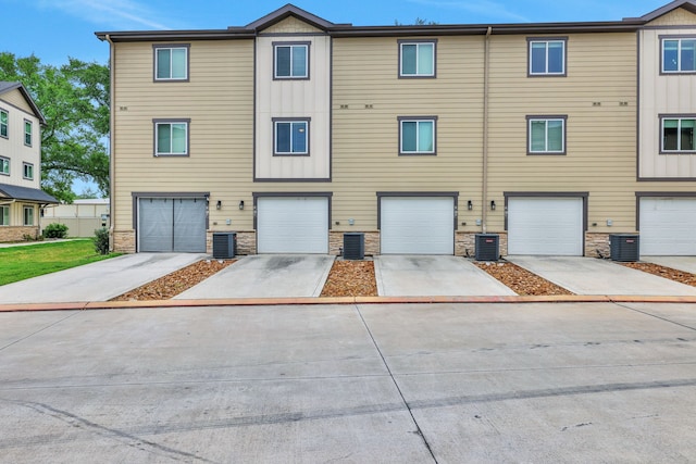 12603 Telge Rd Unit 30C-D, Cypress, TX 77429 - view of property featuring stone siding, central AC unit, a garage, and driveway