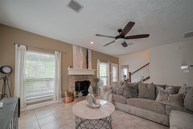 18914 Hikers Trail Dr, Humble, TX 77346 - living area with ceiling fan, light tile patterned floors, a brick fireplace, stairway, and a textured ceiling