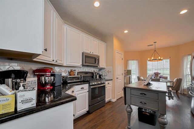 18914 Hikers Trail Dr, Humble, TX 77346 - kitchen with stainless steel appliances, a chandelier, white cabinets, backsplash, and dark wood-type flooring