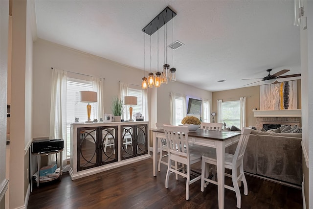 18914 Hikers Trail Dr, Humble, TX 77346 - dining room with dark wood-type flooring, ceiling fan, a textured ceiling, a brick fireplace, and a chandelier
