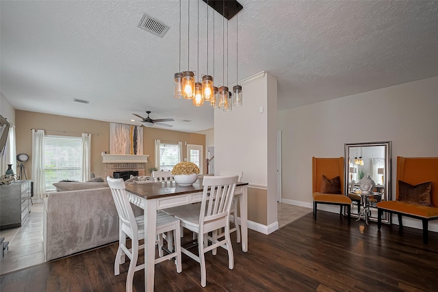 18914 Hikers Trail Dr, Humble, TX 77346 - dining room featuring ceiling fan, a chandelier, wood finished floors, a brick fireplace, and plenty of natural light