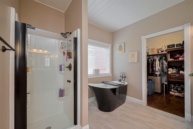 18914 Hikers Trail Dr, Humble, TX 77346 - bathroom with a shower stall, a freestanding bath, ornamental molding, a walk in closet, and baseboards