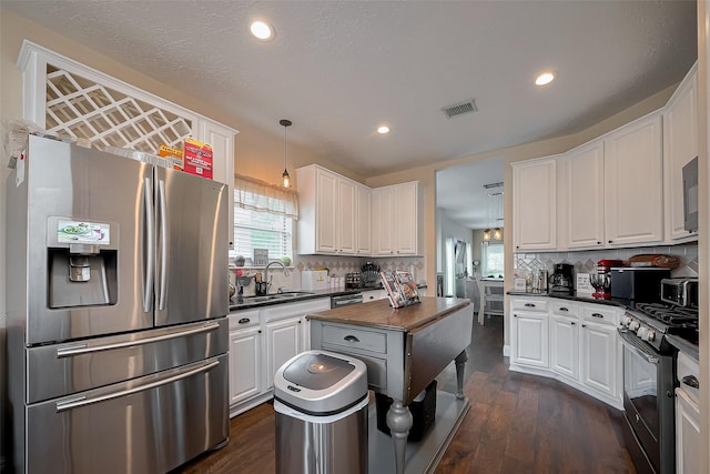 18914 Hikers Trail Dr, Humble, TX 77346 - kitchen with gas range, stainless steel fridge with ice dispenser, a sink, dark countertops, and white cabinetry