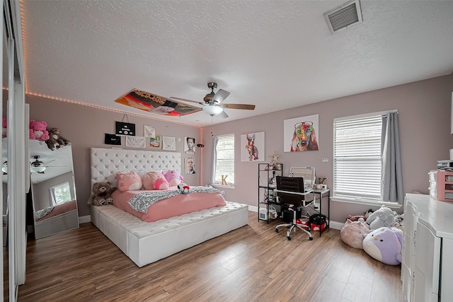 18914 Hikers Trail Dr, Humble, TX 77346 - bedroom featuring wood finished floors, a textured ceiling, baseboards, a ceiling fan, and an office area