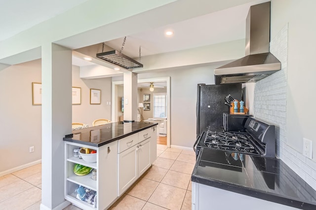 kitchen with light tile patterned floors, open shelves, wall chimney range hood, freestanding refrigerator, and white cabinetry